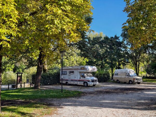 Camper in sosta all'ombra degli alberi nell'area di Tarcento