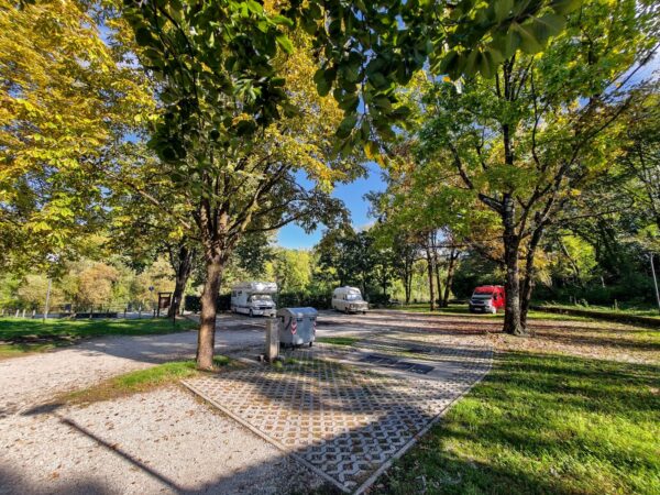 Viale alberato dell'area sosta camper di Tarcento con i camper in fondo